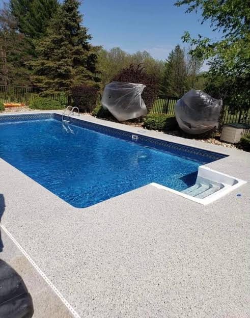 Quartz-coated pool deck around a rectangular pool