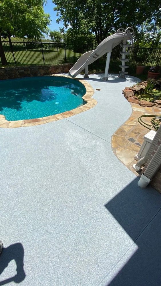 Coated pool deck with a slide and stone border